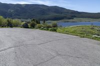 a man riding a skateboard on top of a paved surface near mountains and trees