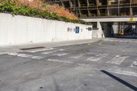 a person riding a skateboard down a paved road next to an office building and sidewalk