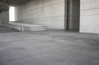 a man that is skateboarding outside of a building on concrete floors that are set up