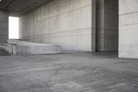 a man that is skateboarding outside of a building on concrete floors that are set up