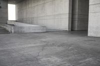 a man that is skateboarding outside of a building on concrete floors that are set up