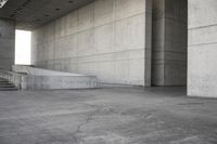 a man that is skateboarding outside of a building on concrete floors that are set up