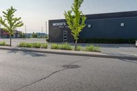 a man wearing glasses is riding on a skateboard on a paved street in front of a sign that says mckinss