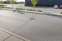 a man wearing glasses is riding on a skateboard on a paved street in front of a sign that says mckinss