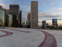 a skateboarder riding over a ramp in the city with buildings in the background