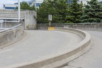 a young boy on a skateboard going down a ramp with trees and buildings in the background