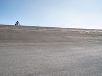 a lone skateboard on the road in a dry field with sky in the background