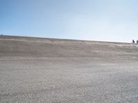 a lone skateboard on the road in a dry field with sky in the background