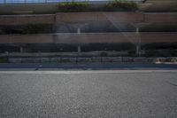 a person riding a skateboard down the middle of a road under a bridge in front of building