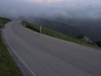 a man riding a skateboard down the middle of a rural road in the evening