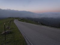 a man riding a skateboard down the middle of a rural road in the evening