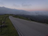 a man riding a skateboard down the middle of a rural road in the evening