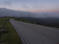 a man riding a skateboard down the middle of a rural road in the evening