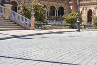 a person riding on a skateboard in a brick walkway way near a tall building