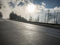 a skateboarder is skating down the snow covered road during a sunny day,