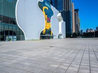 a statue of a man on a skateboard stands in front of the building's entrance