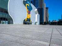 a statue of a man on a skateboard stands in front of the building's entrance