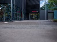 a skateboarder riding on the edge of a skate park in front of large glass walls and windows