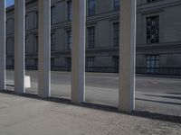 a person riding a skateboard next to some buildings on a concrete sidewalk in the middle of town