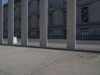 a person riding a skateboard next to some buildings on a concrete sidewalk in the middle of town