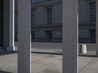 a person riding a skateboard between columns and buildings on a city street in the distance