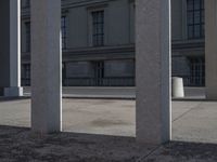 a person riding a skateboard between columns and buildings on a city street in the distance