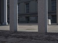 a person riding a skateboard between columns and buildings on a city street in the distance