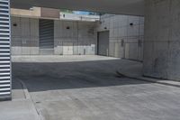 a man riding a skateboard on the side of a concrete sidewalk next to a street