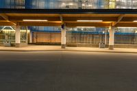 a person on a skateboard in front of an empty building at night with the light shining brightly