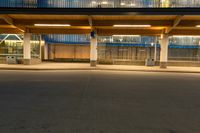 a person on a skateboard in front of an empty building at night with the light shining brightly