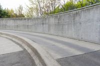 a skateboarder riding on a long, curved surface next to a concrete wall