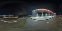 a skateboarder jumps in the air over a half pipe while skateboarding at night