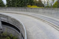 two people on skateboards in the skate park with ramps that are almost round and have two sections that are curved