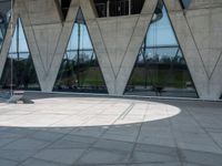 this is an image of a man riding a skateboard outside a building with a large window