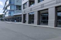 the skateboarder rides down the empty streets near tall buildings on an overcast day