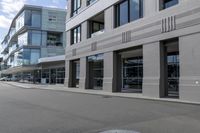 the skateboarder rides down the empty streets near tall buildings on an overcast day