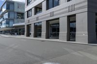 the skateboarder rides down the empty streets near tall buildings on an overcast day