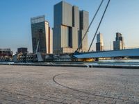 a woman riding a skateboard down a river next to a city dock in the background