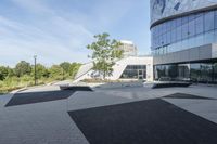 a view of an outside area of an office building with large windows and a circular driveway