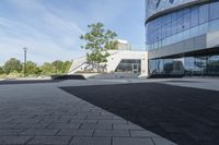 a view of an outside area of an office building with large windows and a circular driveway