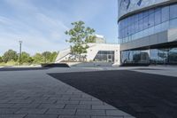 a view of an outside area of an office building with large windows and a circular driveway