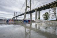 there is a skateboard ramp under the bridge on this cloudy day - - stock photo, image, photograph, image