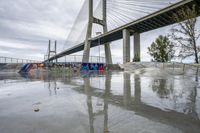 there is a skateboard ramp under the bridge on this cloudy day - - stock photo, image, photograph, image