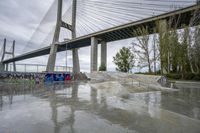 there is a skateboard ramp under the bridge on this cloudy day - - stock photo, image, photograph, image