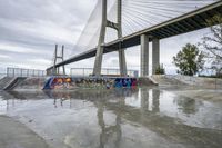 there is a skateboard ramp under the bridge on this cloudy day - - stock photo, image, photograph, image