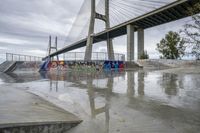 there is a skateboard ramp under the bridge on this cloudy day - - stock photo, image, photograph, image