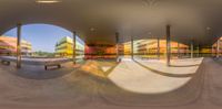 a photo taken with a fish eye lens of a skateboard park and several benches and tables