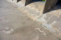 someone skating on the side of a ramp with their feet off the wall and one hand