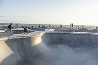 a man riding his skateboard through the middle of a concrete bowl at a skate park