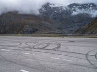 an image of a person skating on a runway in the snow and mountains below it